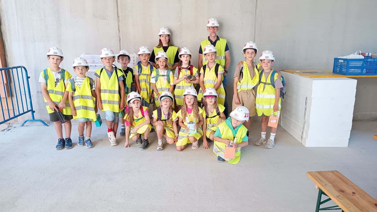 Betreten der Baustelle erlaubt 2026 - Gruppenfoto der Zweitklässler mit Bauhelmen und Warnwesten im Rohbau