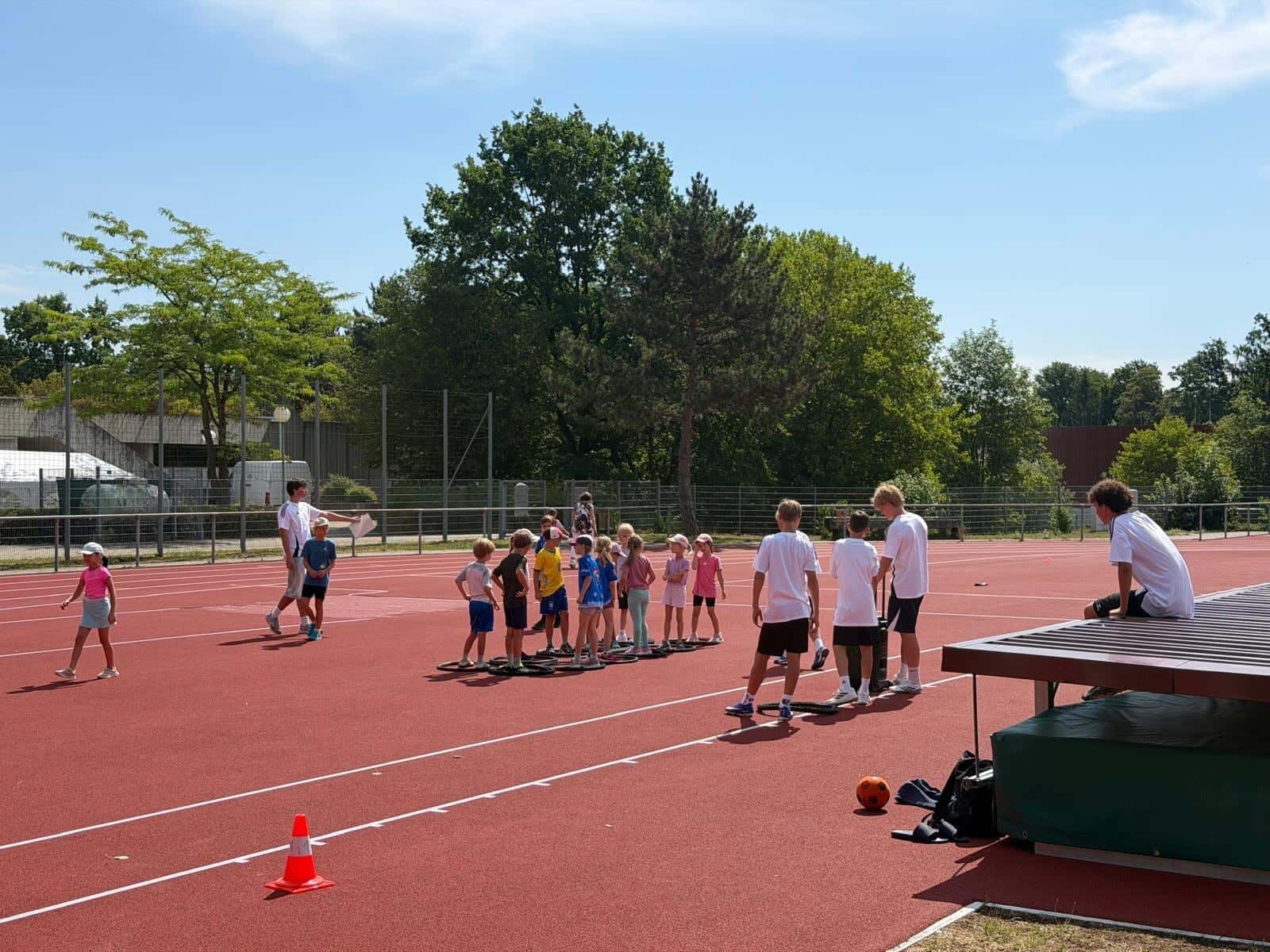 Bundesjugendspiele 2026 - Schülerinnen und Schüler an einer Bewegungsstation mit Reifen auf der Laufbahn