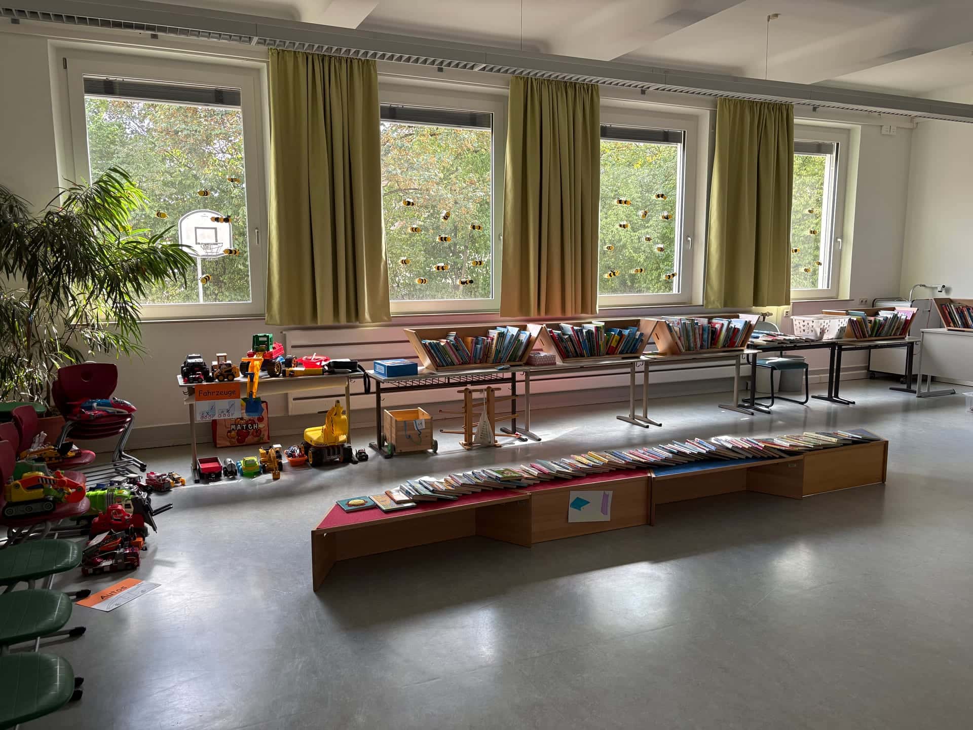 Flohmarkt 2026 - Klassenzimmer mit Kinderbüchern auf Bänken und Tischen und Spielzeugfahrzeugen am Fenster