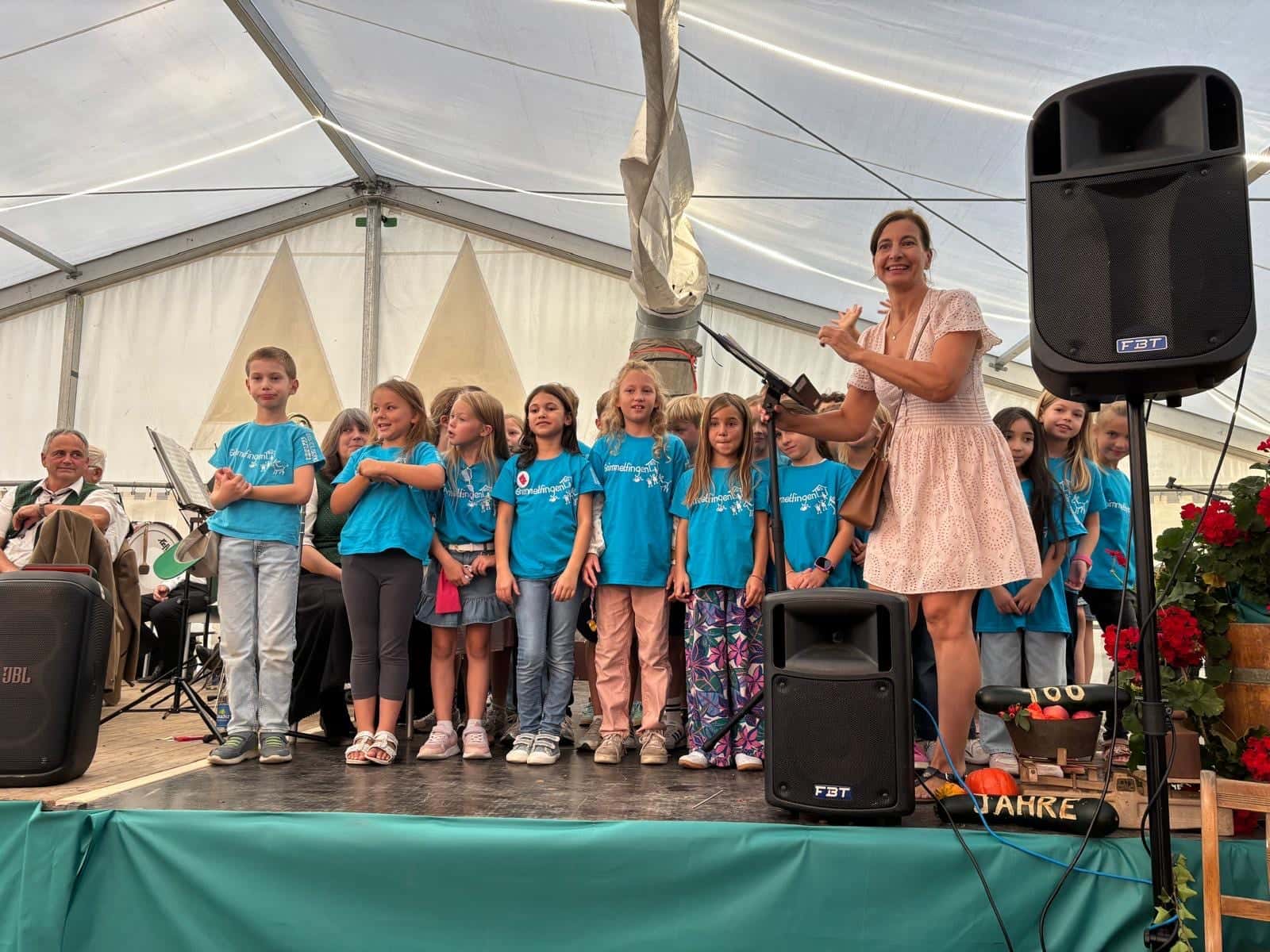 Kirchweih 2026 - Der Schulchor in türkisen Grimmelfingen-T-Shirts auf der Bühne im Festzelt