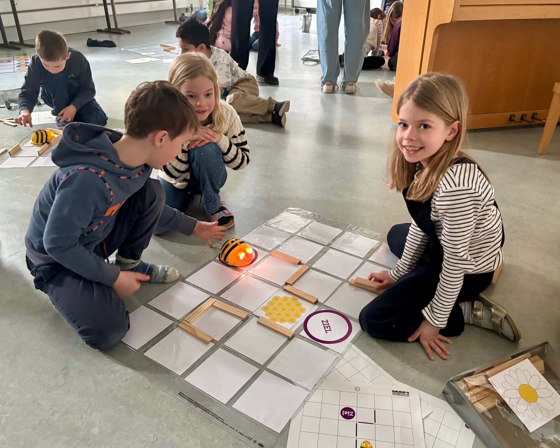 Mobiles Medienlabor 2026 - Klasse 1 programmiert den BeeBot auf einem Spielfeld