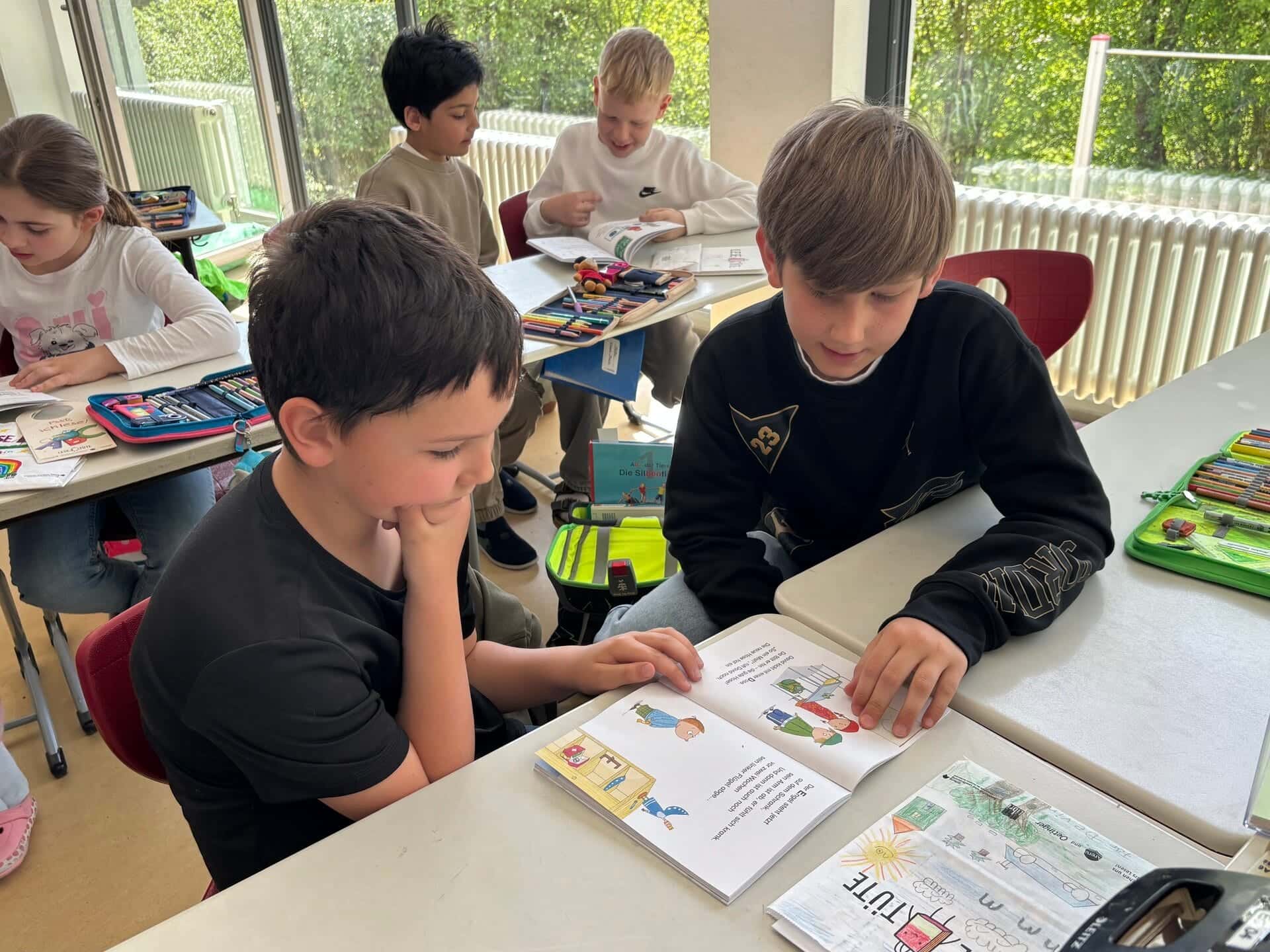 Patenkinder 2026 - Zwei Jungen aus Klasse 1 und Klasse 4 lesen zusammen in einem Buch