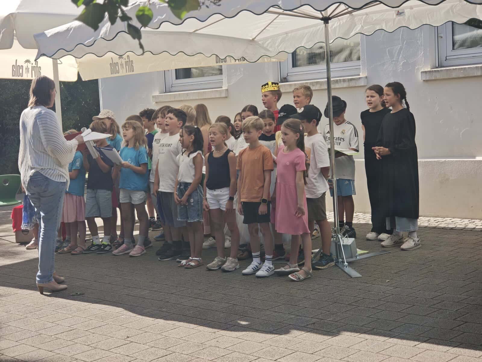 Schulfest 2026 - Der Schulchor singt unter Leitung einer Lehrerin auf dem Schulhof