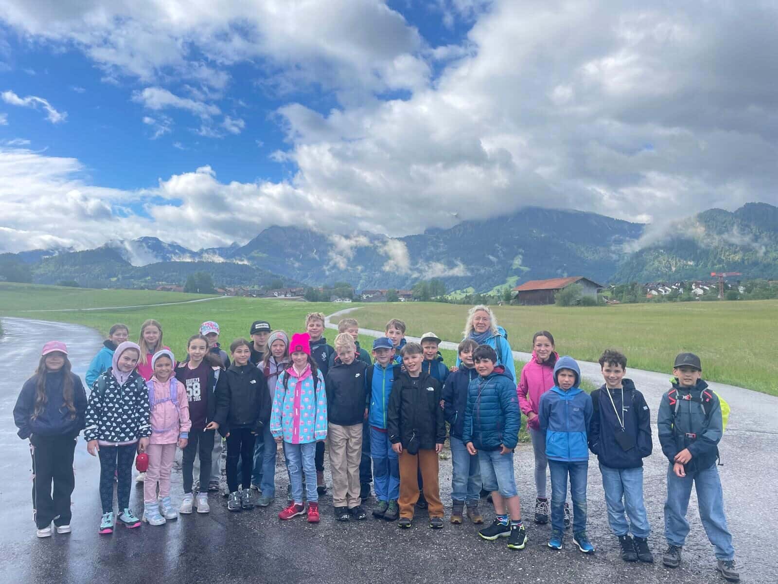 Schullandheim 2026 - Gruppenfoto der Klasse 3/4 vor der Bergkulisse bei Pfronten