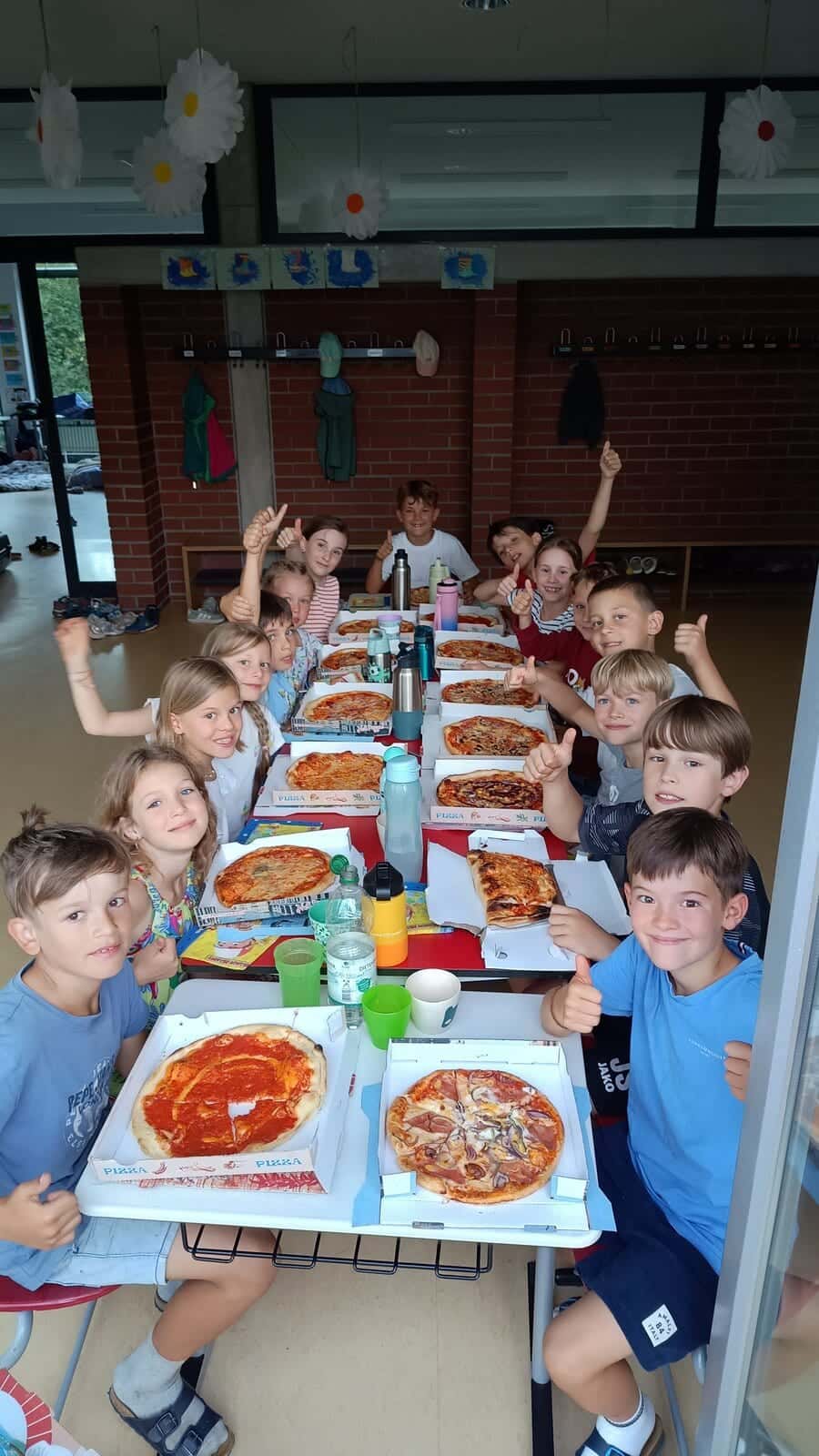 Schulübernachtung 2026 - Die Zweitklässler stärken sich mit Pizza und zeigen den Daumen hoch