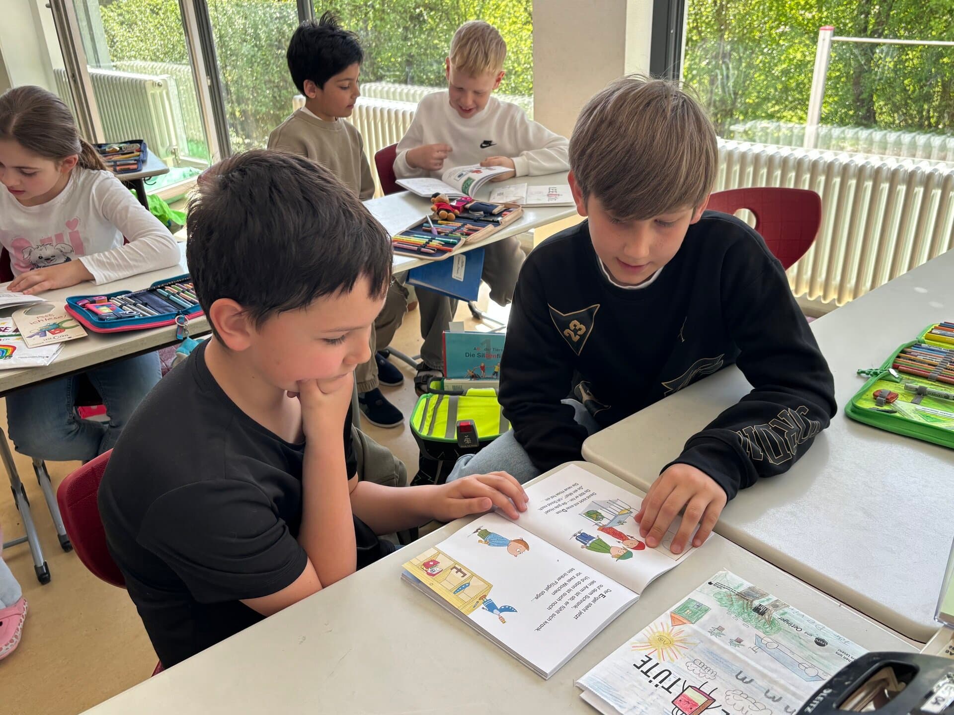 Patenkinder 2026 - Zwei Jungen aus Klasse 1 und Klasse 4 lesen zusammen in einem Buch